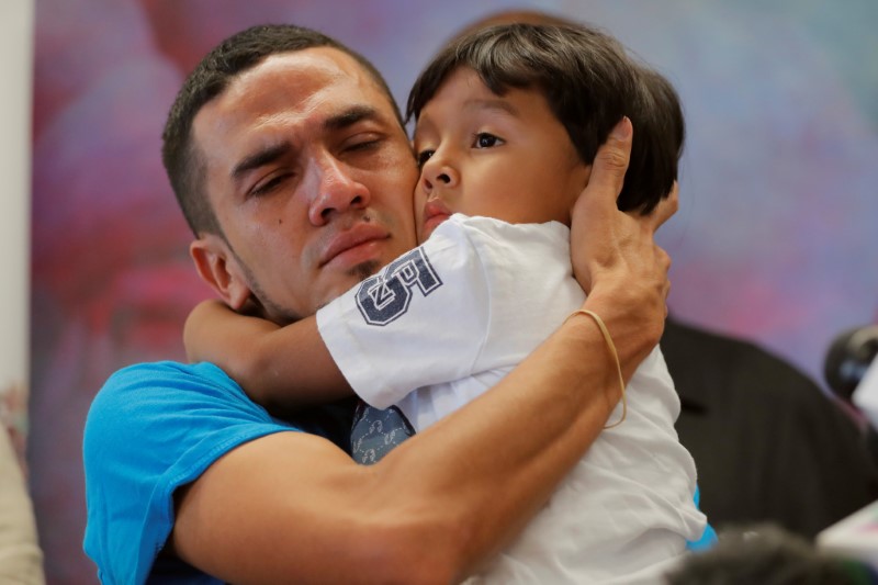 © Reuters. Javier, a 30 year old from Honduras, holds his 4 year old son William during a media availability in New York after they were reunited after being separated for 55 days following their detention at the Texas border