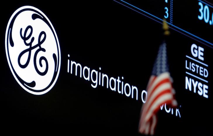 © Reuters. FILE PHOTO -The ticker and logo for General Electric Co. is displayed on a screen at the post where it is traded on the floor of the NYSE