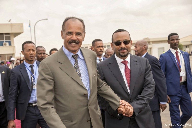 © Reuters. Eritrean President Isaias Afwerki and Ethiopia's Prime Minister Abiy Ahmed and walk together at Asmara International Airport
