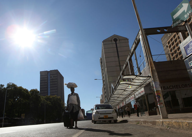 © Reuters. FILE PHOTO: A woman walks along an empty street in the central business district of Harare