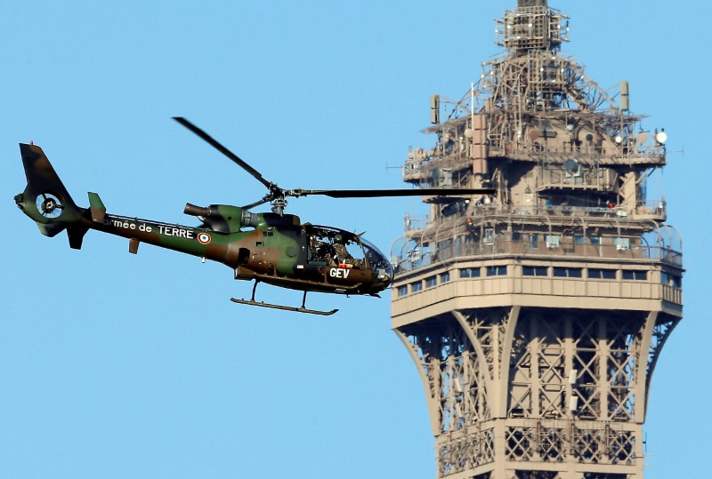 © Reuters. Helicóptero militar passa pela Torre Eiffel, em Paris