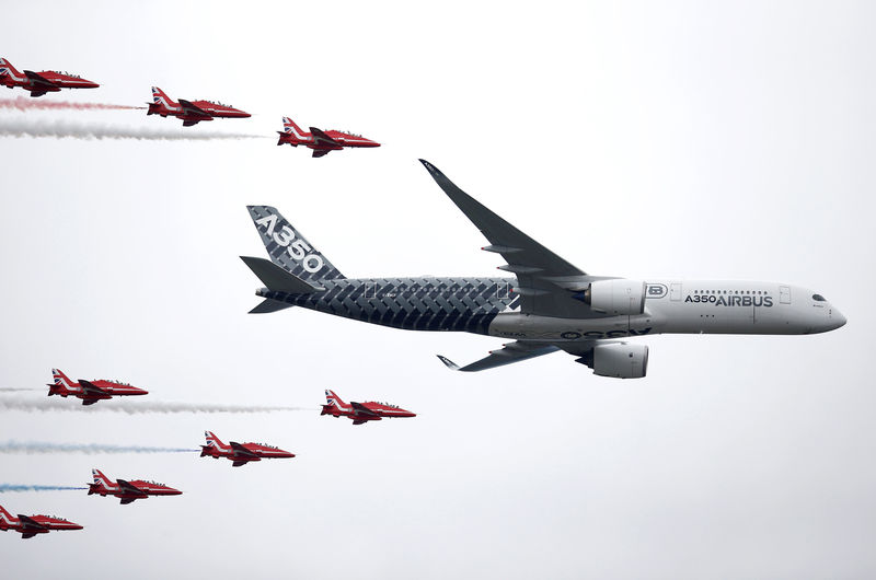 © Reuters. FILE PHOTO: An Airbus A350 aircraft flies in formation with Britain's Red Arrows flying display team at the Farnborough International Airshow in Farnborough