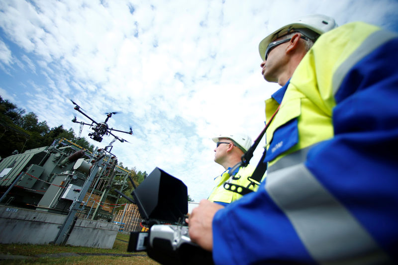 © Reuters. Workers operate a drone to survey high-voltage power lines of electric company Westnetz near Wilnsdorf