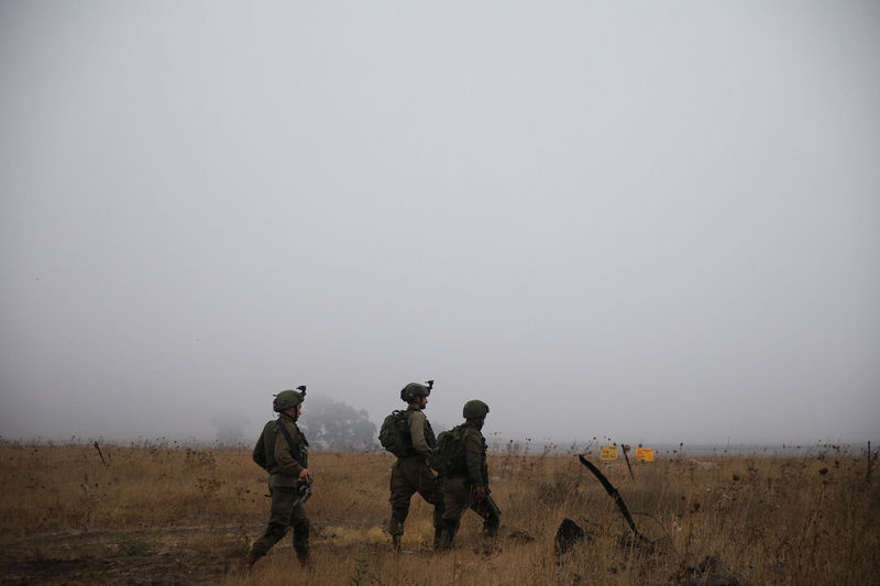 © Reuters. Israeli soldiers patrol the area where Syrians cross the armistice line from Syria to the Israeli-occupied Golan Heights to get medical treatment in Israel