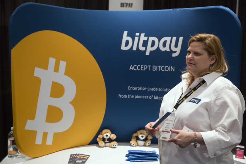 © Reuters. A woman explains how bitpay, a company designed to help companies use virtual currency, to attendee during Inside Bitcoins: The Future of Virtual Currency Conference in New York