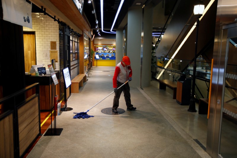 © Reuters. FILE PHOTO: A worker mops the floor at Lotte World Mall in Seoul