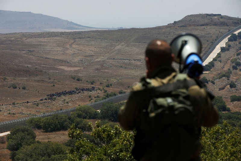 © Reuters. Soldado israelense alerta sírios que se aproximavam da fronteira Síria-Israel nas ocupadas Colinas de Golã