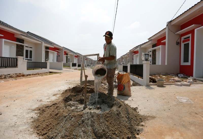 © Reuters. A worker mixes cement at a housing project in Tajur Halang neighbourhood, south of Jakarta