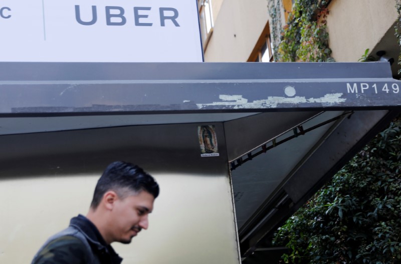 © Reuters. Man walks by under an Uber logo in Mexico City