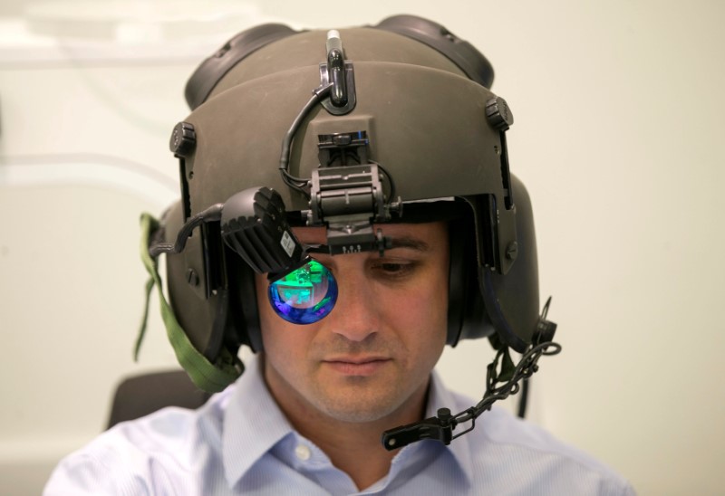 © Reuters. FILE PHOTO: A man demonstrates wearing Elbit System's advanced helmet mounted system, at their offices in Haifa