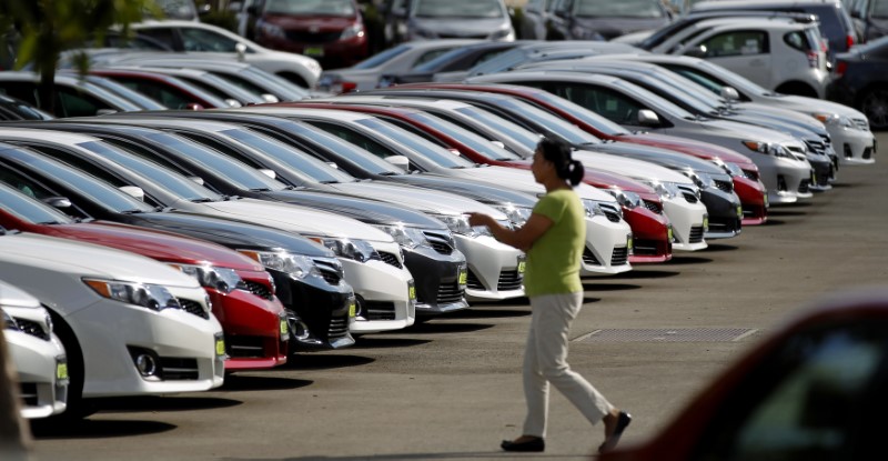 © Reuters. A woman walks by vehicles for sale at a Toyota dealership in Pasadena