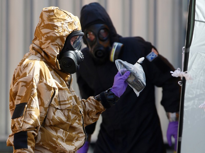 © Reuters. FILE PHOTO: Forensic investigators, wearing protective suits, emerge from the rear of John Baker House, after it was confirmed that two people had been poisoned with the nerve-agent Novichok, in Amesbury