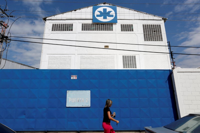 © Reuters. FILE PHOTO - A woman walks outside a Kimberly-Clark building in Maracay