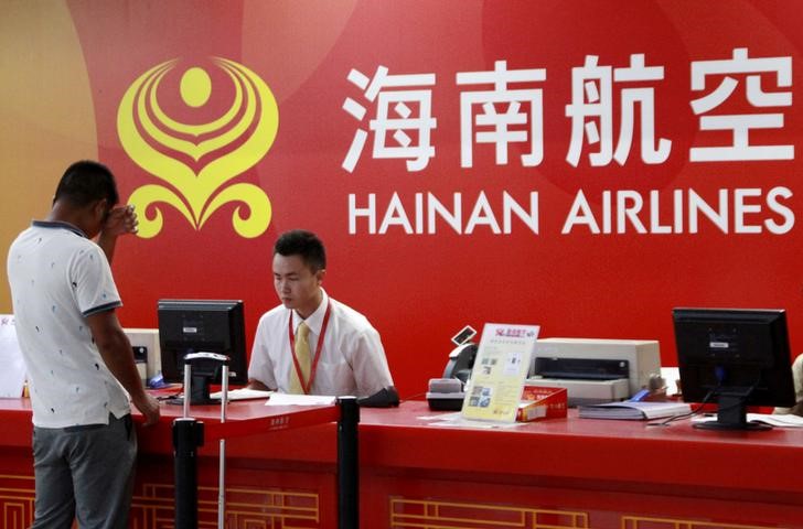 © Reuters. FILE PHOTO: Customer stands in front of a counter of Hainan Airlines at an airport in Haikou
