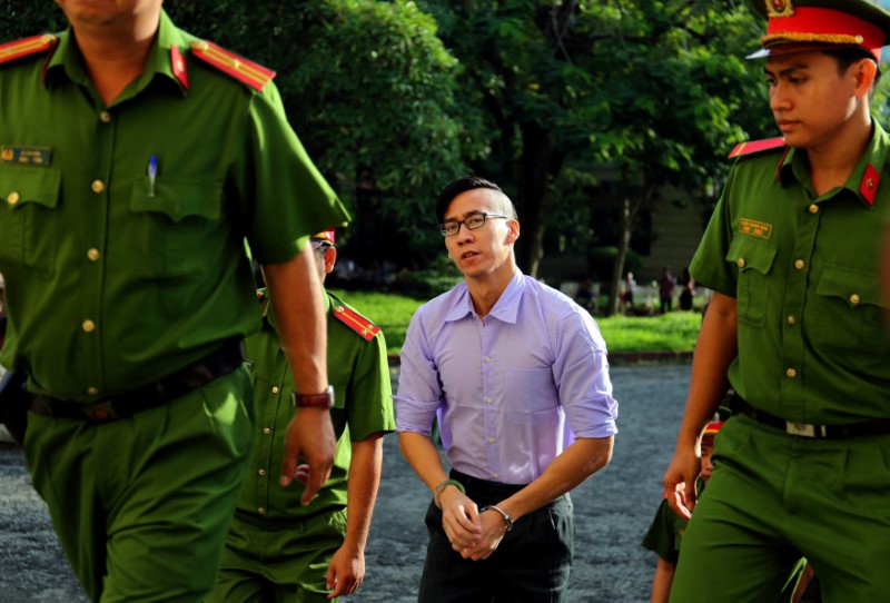 © Reuters. U.S. citizen Will Nguyen is escorted by police before his trial at a court in Ho Chi Minh city