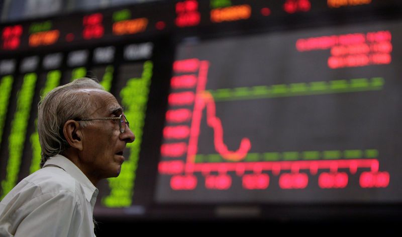 © Reuters. FILE PHOTO: A man monitors an electronic board displaying stock prices at the Karachi Stock Exchange