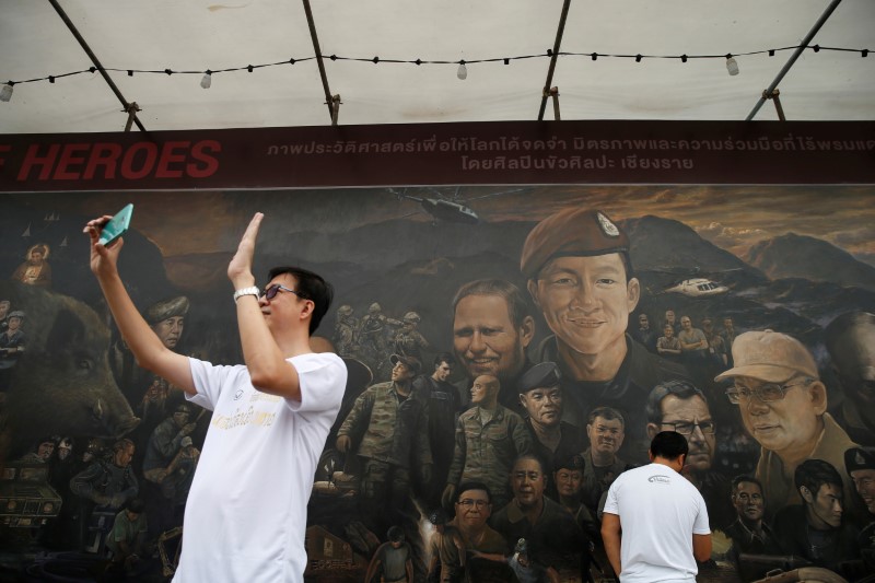 © Reuters. Homem tira selfie em frente a painel em homenagem a resgate de meninos em caverna na Tailândia