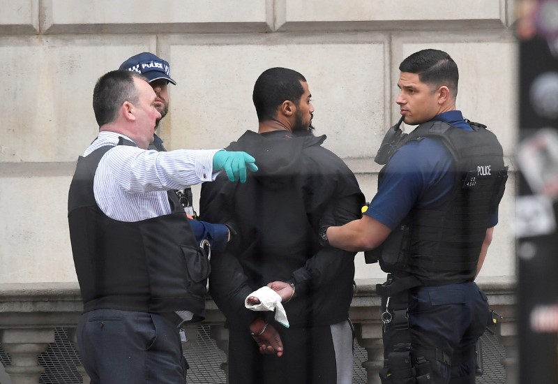 © Reuters. FILE PHOTO: Khalid Mohammed Omar Ali is held by police in Westminster he was arrested on Whitehall in central London