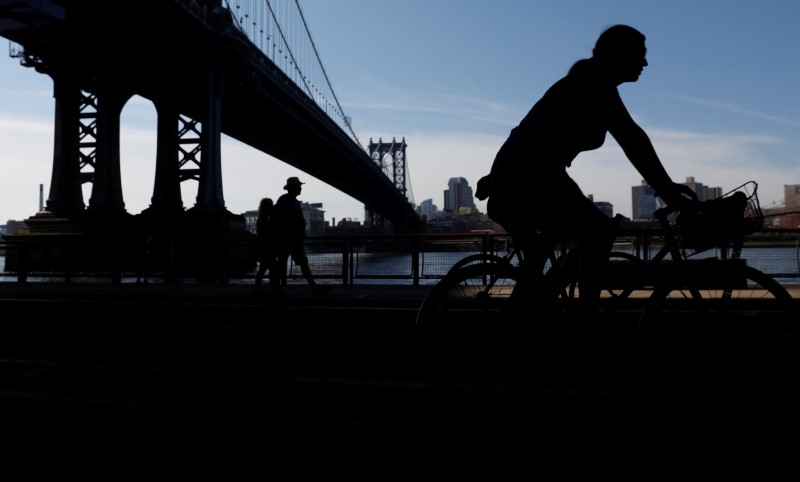 © Reuters. People are seen in silhouette underneath the Manhattan Bridge during sunny weather in Manhattan, New York