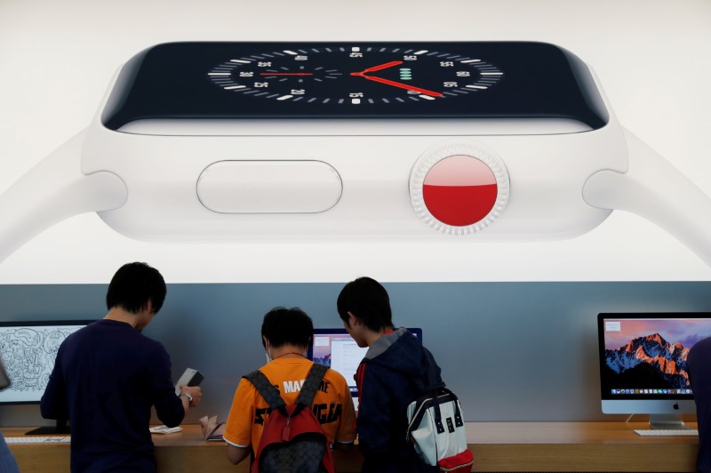 © Reuters. Clientes embaixo de uma foto promocional do novo Apple Watch 3 em Tóquio, Japão