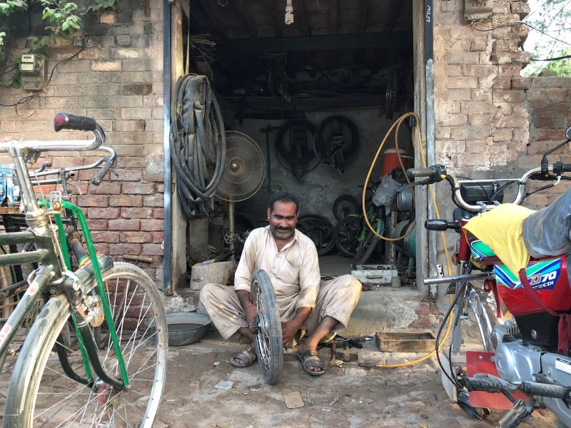 © Reuters. A man fixes a motorcycle tyres at his workshop in the town of Rabwah