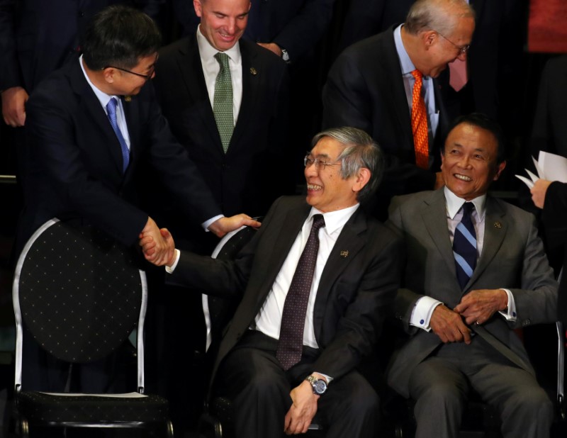 © Reuters. South Korean Finance Minister Kim Dong-yeon (L) shakes hands with Bank of Japan (BOJ) Governor Kuroda alongside Japan's Minister of Finance Aso before posing for the official photo at the G20 Meeting of Finance Ministers in Buenos Aires