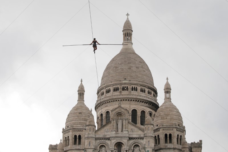 © Reuters. La equilibrista Tatiana-Mosio Bongonga avanza por la cuerda floja por la colina de Monmartre, hacia la basílica del Sacré Coeur, en París, Francia.
