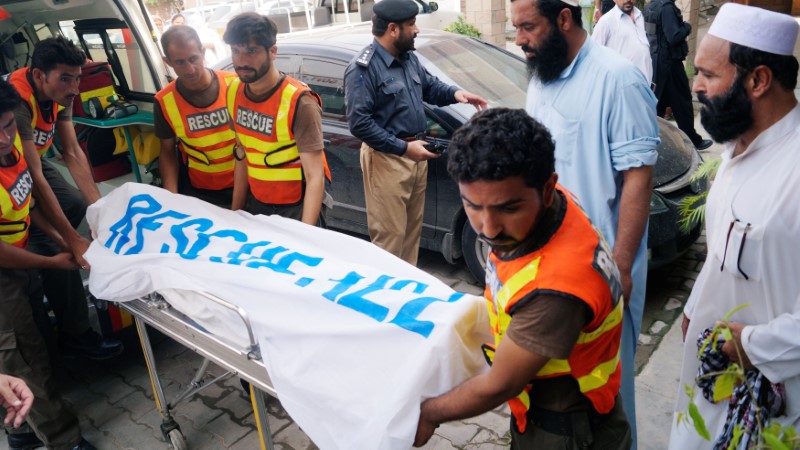 © Reuters. Rescue workers move the body of Ikramullah Gandapur, a candidate of the Pakistan Tehreek-e-Insaf (PTI), or Pakistan Justice Movement, who was killed in a suicide attack, outside hospital morgue in Dera Ismail Khan
