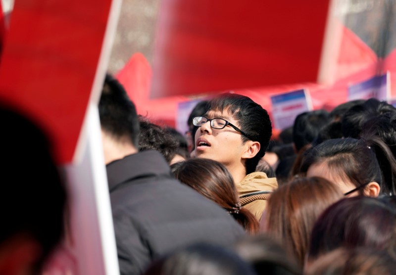 © Reuters. A job seeker looks at offers at a job fair at Liberation Square in Shijiazhuang