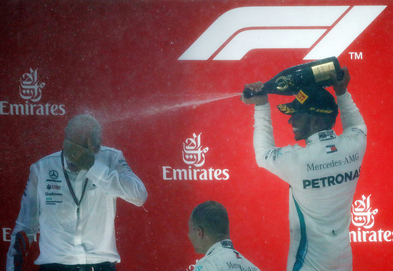 © Reuters. El conductor británico de Fórmula 1 Lewis Hamilton celebra en el podio con el jefe de Mercedes-Benz, Dieter Zetsche, después de ganar el Gran Premio de Alemania en Hockenheimring, Hockenheim, Alemania