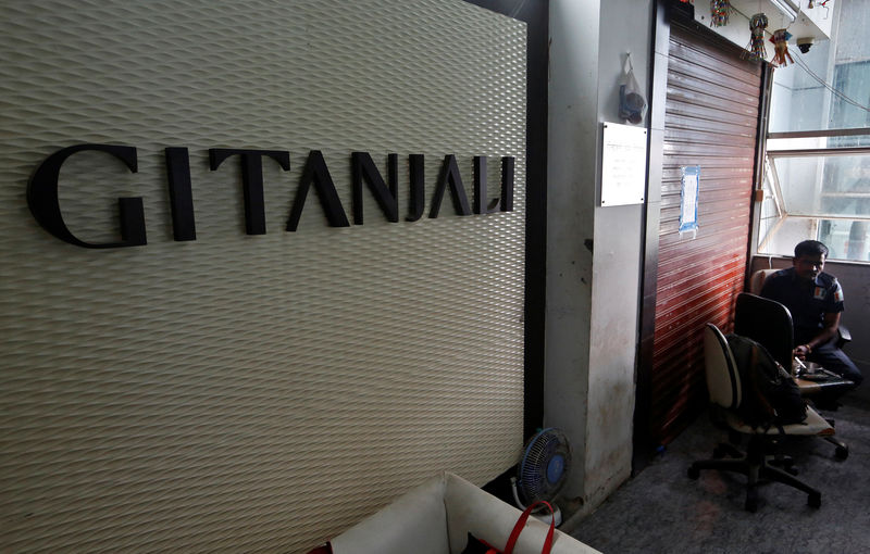 © Reuters. A security guard sits beside a sealed office of Gitanjali jewellers in Mumbai