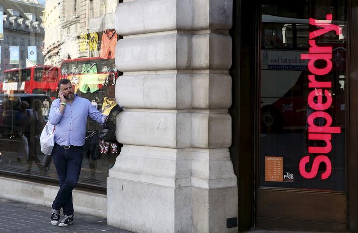© Reuters. FILE PHOTO - A man stands outside a Superdry store in central London