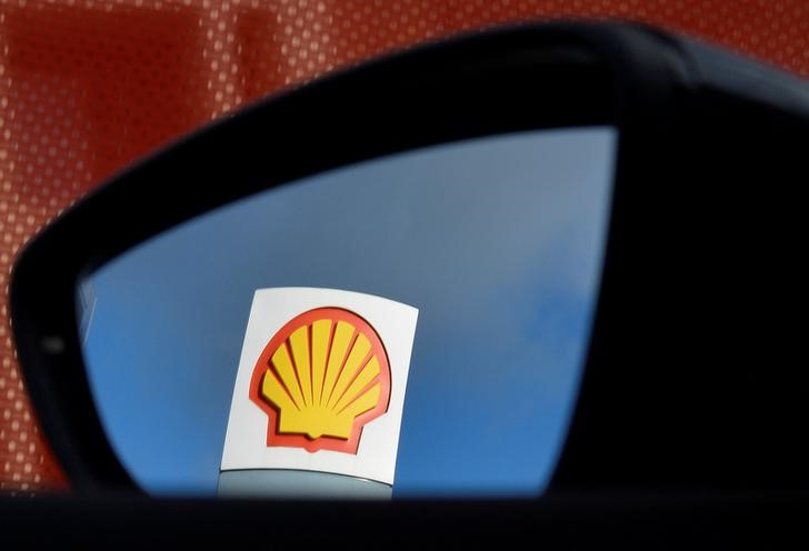 © Reuters. FILE PHOTO: A Shell logo is seen reflected in a car's side mirror at a petrol station in west London