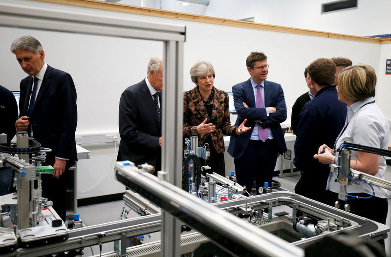 © Reuters. FILE PHOTO: Britain's Prime Minister Theresa May, Chancellor of the Exchequer Philip Hammond and Secretary of State for Business Greg Clark visit an engineering training facility in the West Midlands