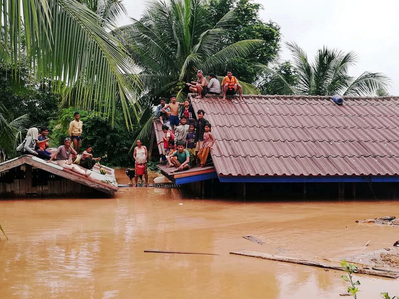 © Reuters. Moradores abrigados em telhados após rompimento de barragem de hidrelétrica no Laos