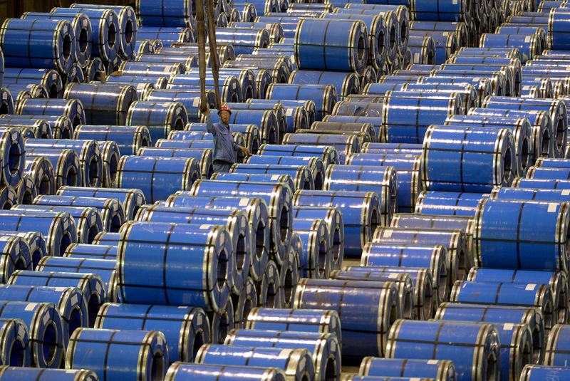 © Reuters. FILE PHOTO:  An employee works among stainless steel sheets at a steel factory in Taiyuan