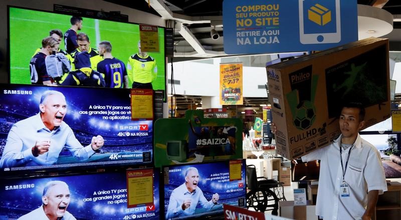 © Reuters. Funcionário carrega televisor em loja em São Paulo