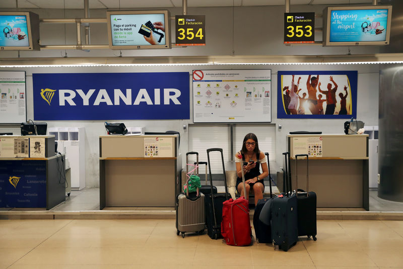 © Reuters. A stranded Ryanair passenger checks her phone at the Adolfo Suarez Madrid Barajas airport in Madrid