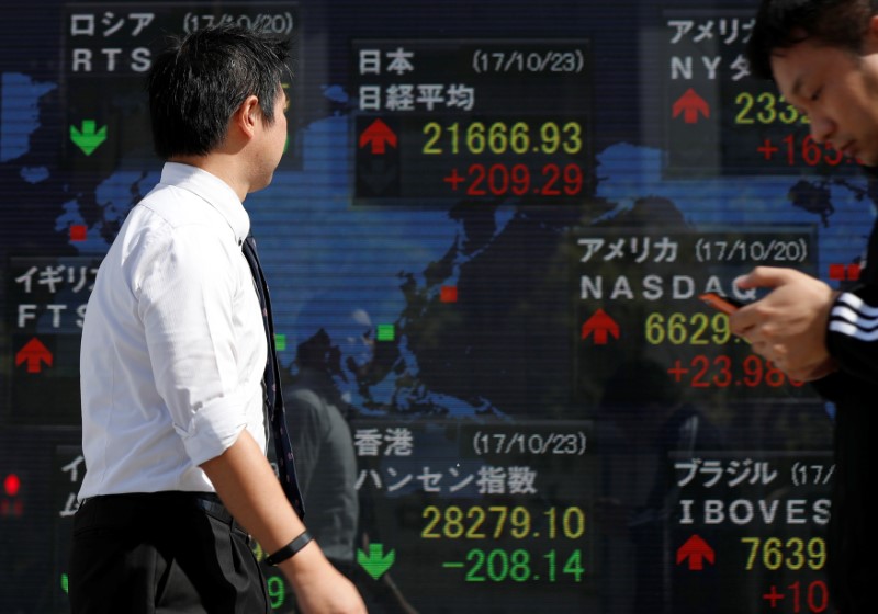 © Reuters. Tokyo, il tabellone elettronico di un brokerage con l'andamento delle principali borse