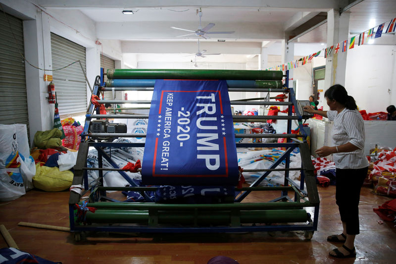 © Reuters. Funcionária produz bandeiras para reeleição de Trump em fábrica em Anhui, na China