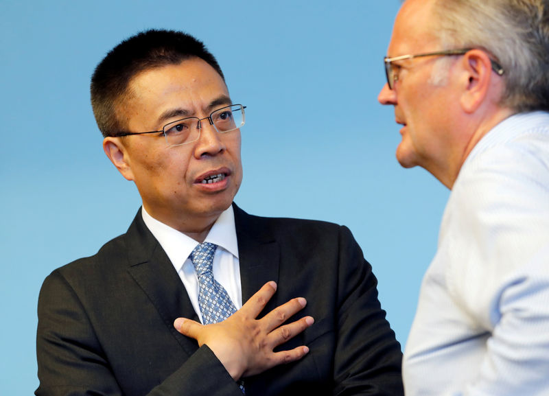 © Reuters. Zhang Chinese Ambassador to the WTO speaks with Rockwell Director of Information of the WTO at the start of the General Council meeting in Geneva