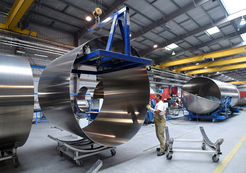 © Reuters. A worker at German manufacturer of silos and liquid tankers, Feldbinder Special Vehicles, moves rolls of aluminium at the company's plant in Winsen