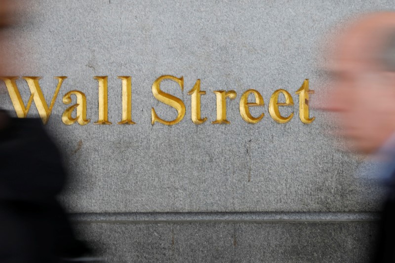 © Reuters. People walk by a Wall Street sign close to the NYSE in New York