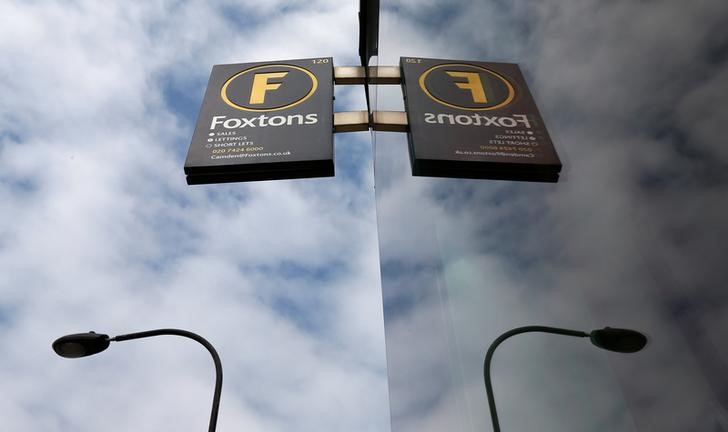 © Reuters. FILE PHOTO: A Foxtons estate agent sign is seen reflected in the window at a branch in north London