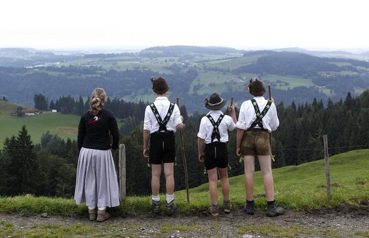 © Reuters. Юные баварские фермеры смотрят на долину перед началом пути в деревню Оберштауфен