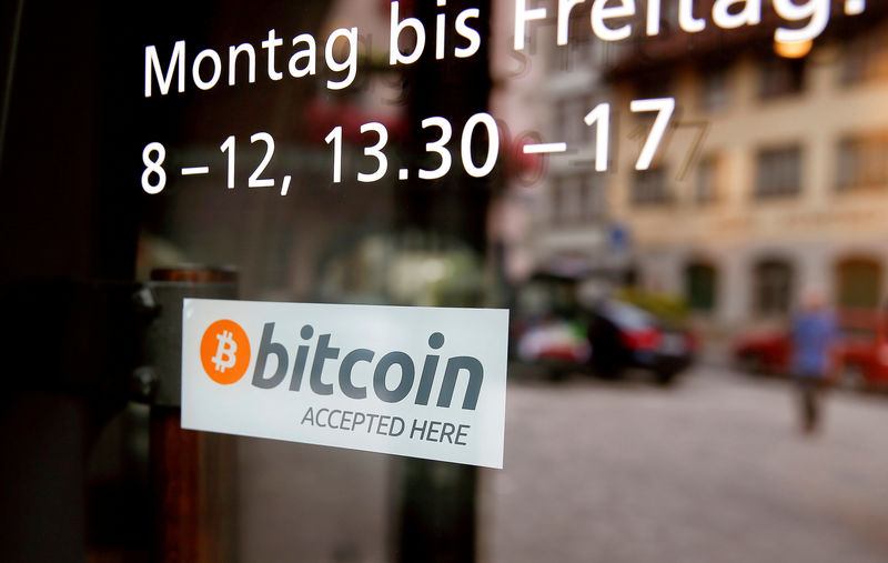 © Reuters. FILE PHOTO: A sticker that reads "Bitcoin accepted here" is displayed at the entrance of the Stadthaus town hall in Zug