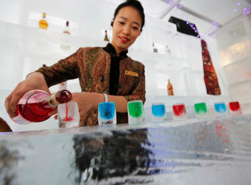 © Reuters. FILE PHOTO -  A waitress pours liquor into ice cups on an ice counter during a photo opportunity at the Ice Palace in Shangri-La Hotel in Harbin