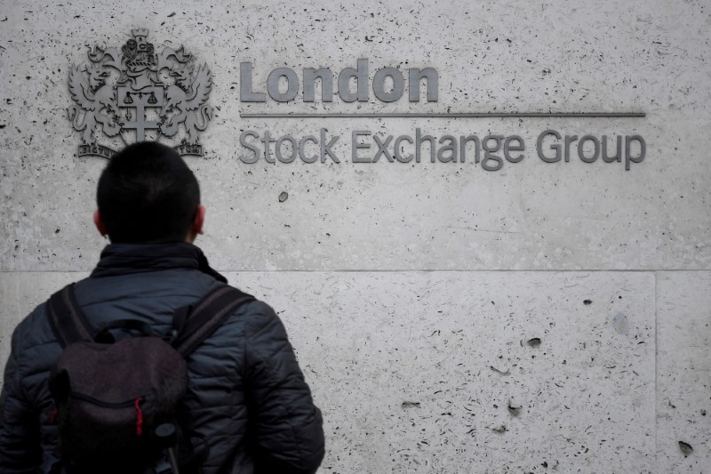 © Reuters. FILE PHOTO: People walk past the London Stock Exchange Group offices in the City of London, Britain