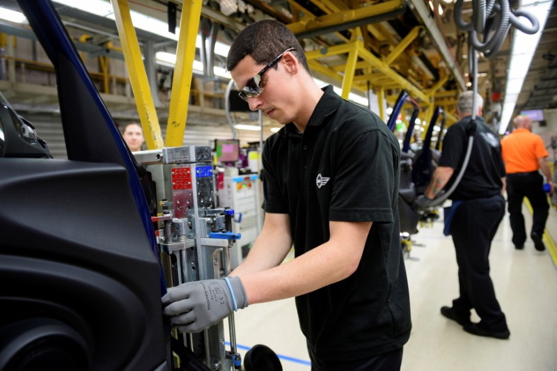 © Reuters. FILE PHOTO: Workers assemble cars at the plant for the Mini range of cars in Cowley, near Oxford