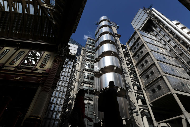 © Reuters. People walk outside Lloyds of London's headquarters in the City of London